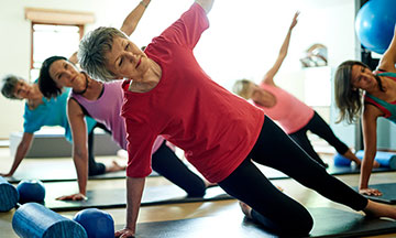 Aufnahme einer Gruppe von Frauen, die das Side Plank Workout in einer Pilates-class machen